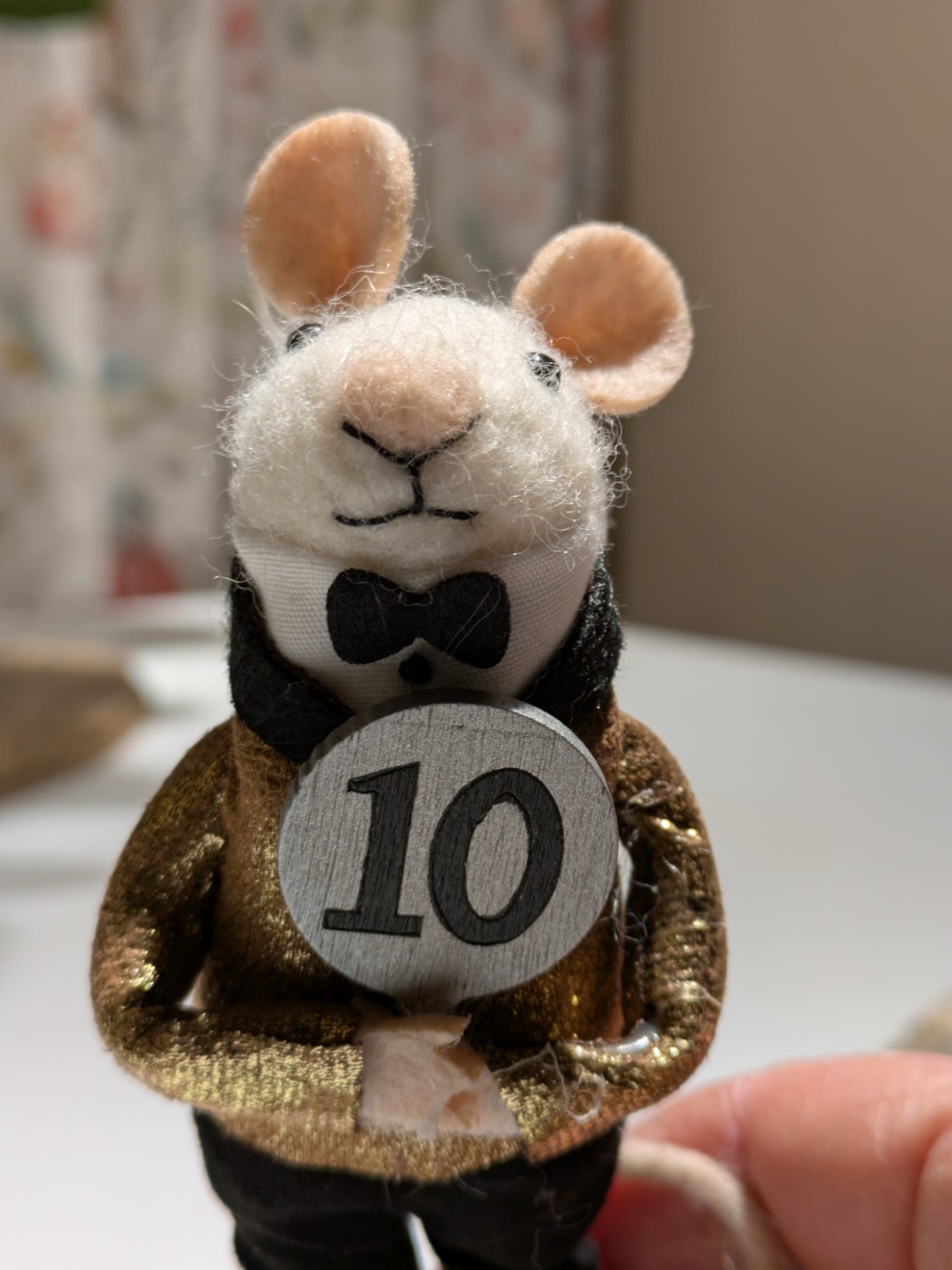 A mouse toy dressed in a sparkly jacket holding up a "10" paddle for the Strictly Come Dancing Final. 