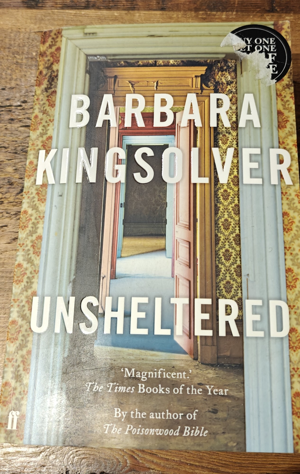 The front cover of Barbara Kingsolver's _Unsheltered_. It shows a series of open doors leading through to one another. 