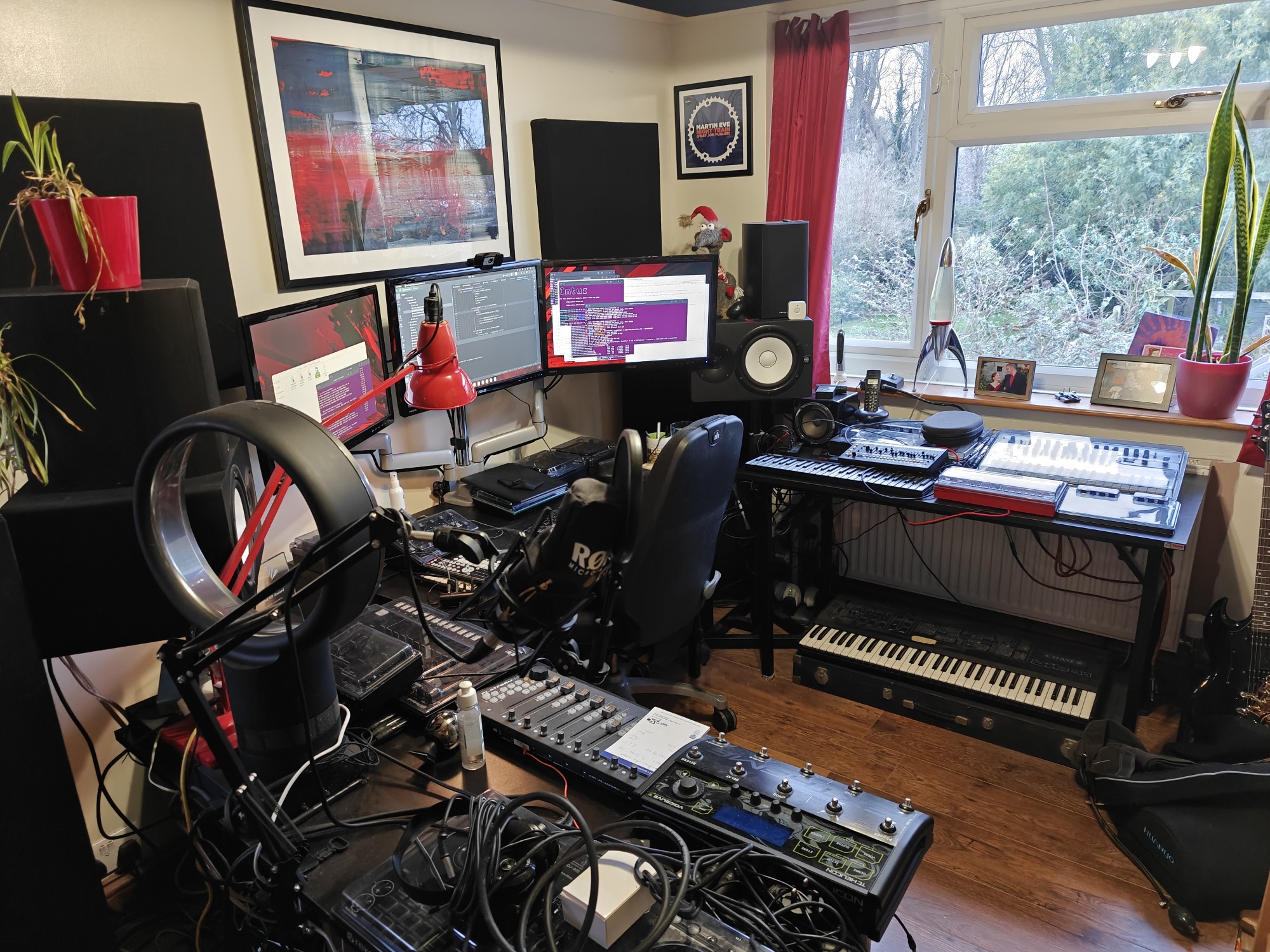 A picture of my office. There are a lot of synthesizers and a computer with three monitors. It's not terribly tidy even now after the cleanup. 