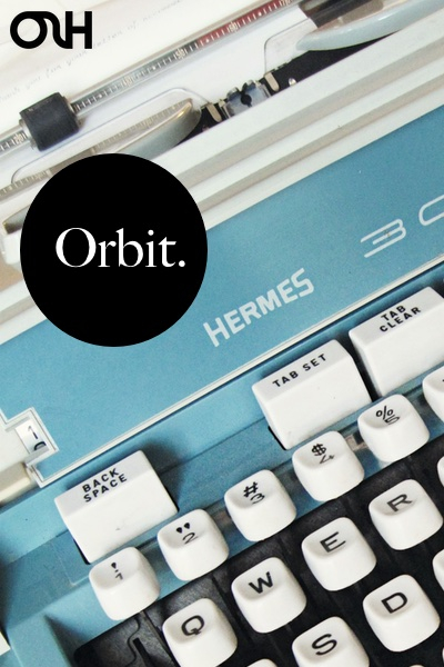 A cover image for the journal Orbit, with the text Orbit in a black circle atop a light blue typewriter.