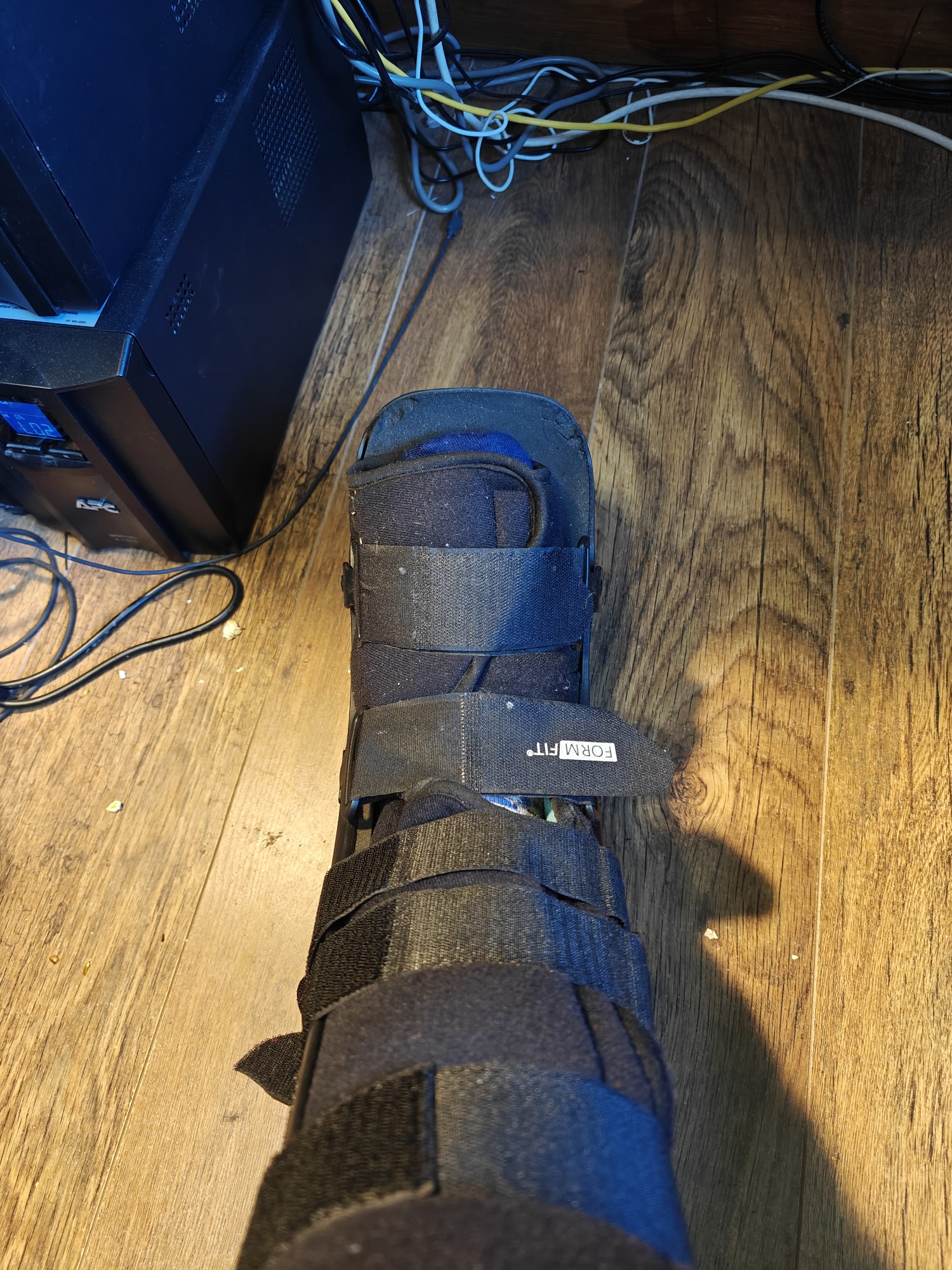 My foot in a black restraining boot for fractures 