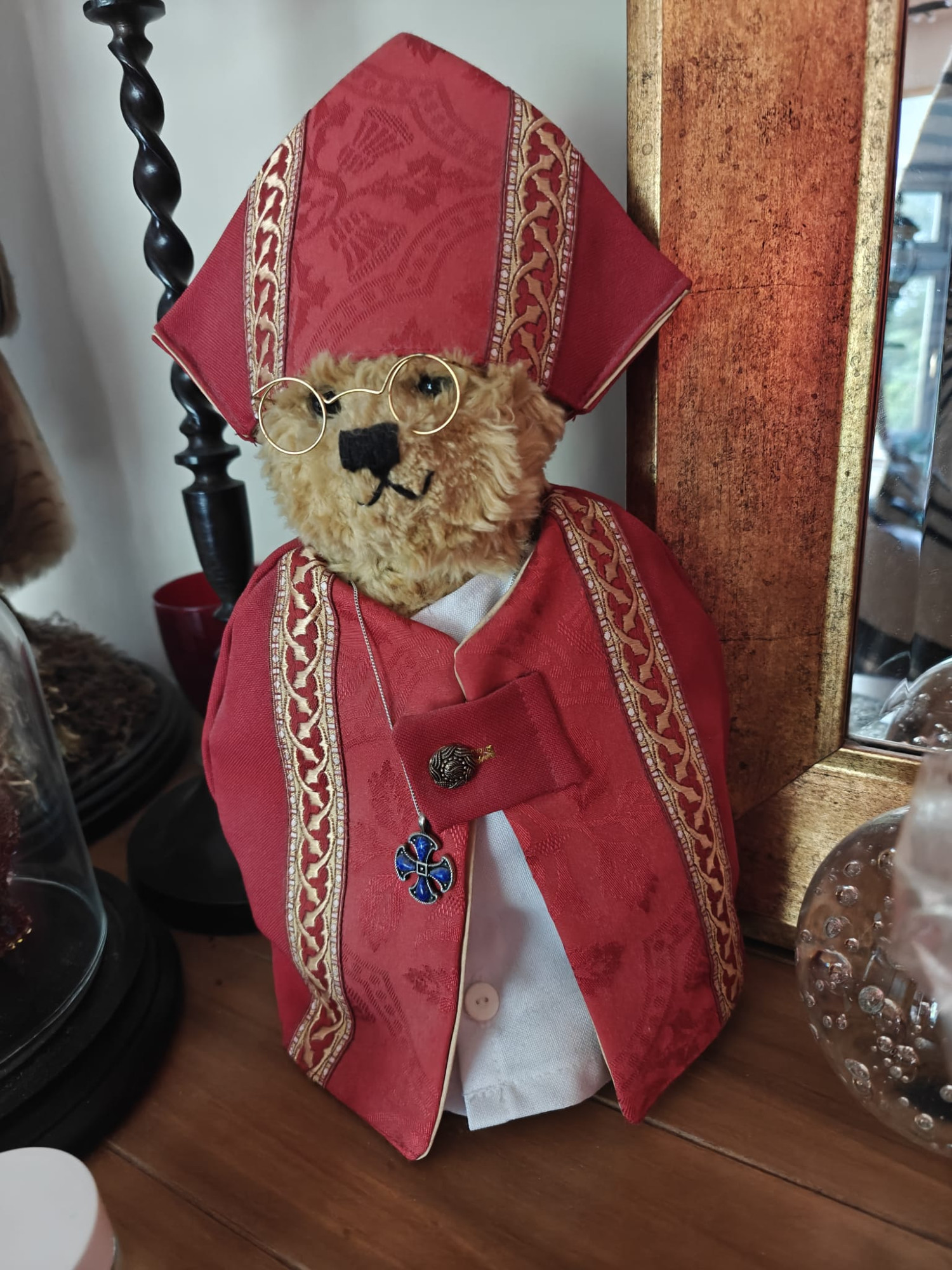 A teddy bear dressed in red clerical robes