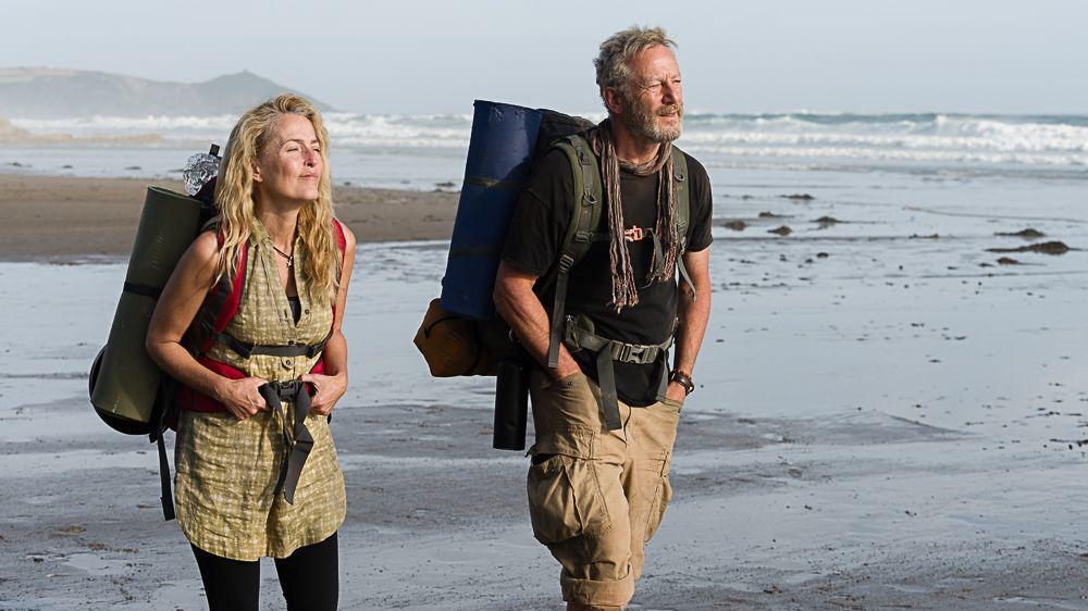 A picture of Gillian Anderson and Jason Isaacs hiking in The Salt Path 