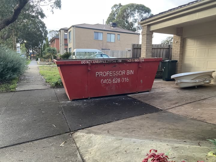 A refuse skip that says "PROFESSOR BIN" on the side