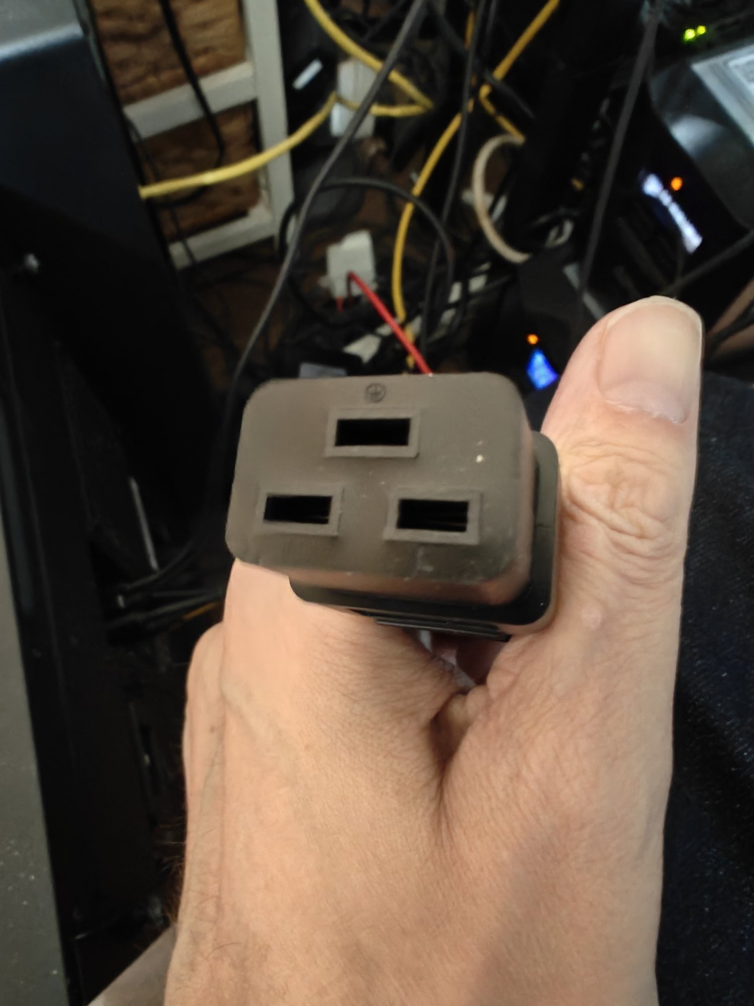 A picture of a plug with three rectangular grooves of equal size in a pyramid formation. 