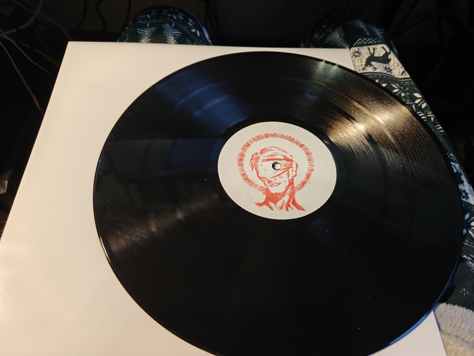 A record with a stamp in the middle of the ALFOS logo - a blindfolded man