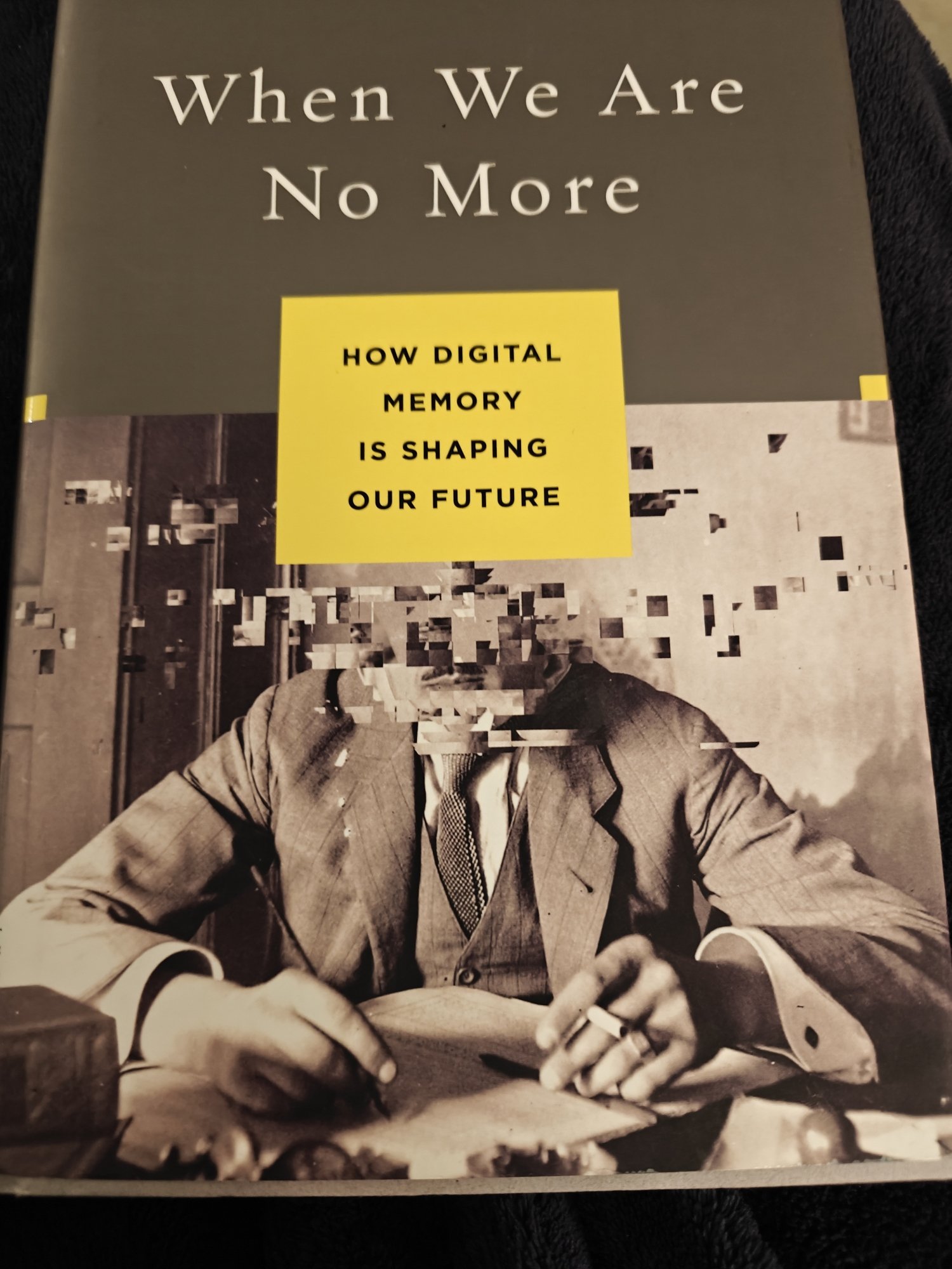 The cover of Abby Smith Rumsey's _When We Are No More: How Digital Memory Is Shaping Our Future_. It features a man with pixellated face with a grey upper half of the book jacket and a yellow box with the subtitle in the middle, just above where the face should be. 