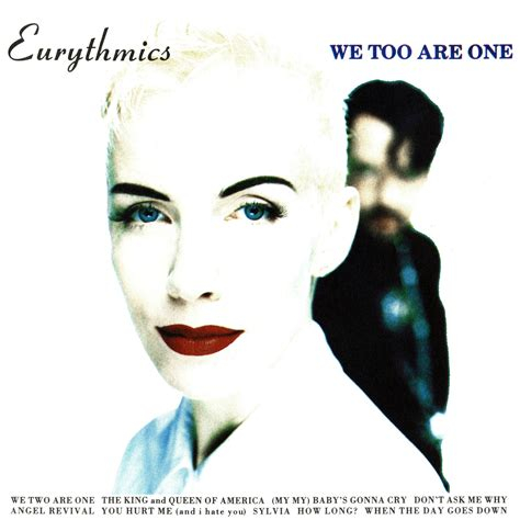 The front cover of the Eurythmics album We Too Are One. It features Annie Lennox at the front, with a very pale face and bright red lipstick. Dave Stewart is in the background of the shot, but blurred and he is dressed all in black.