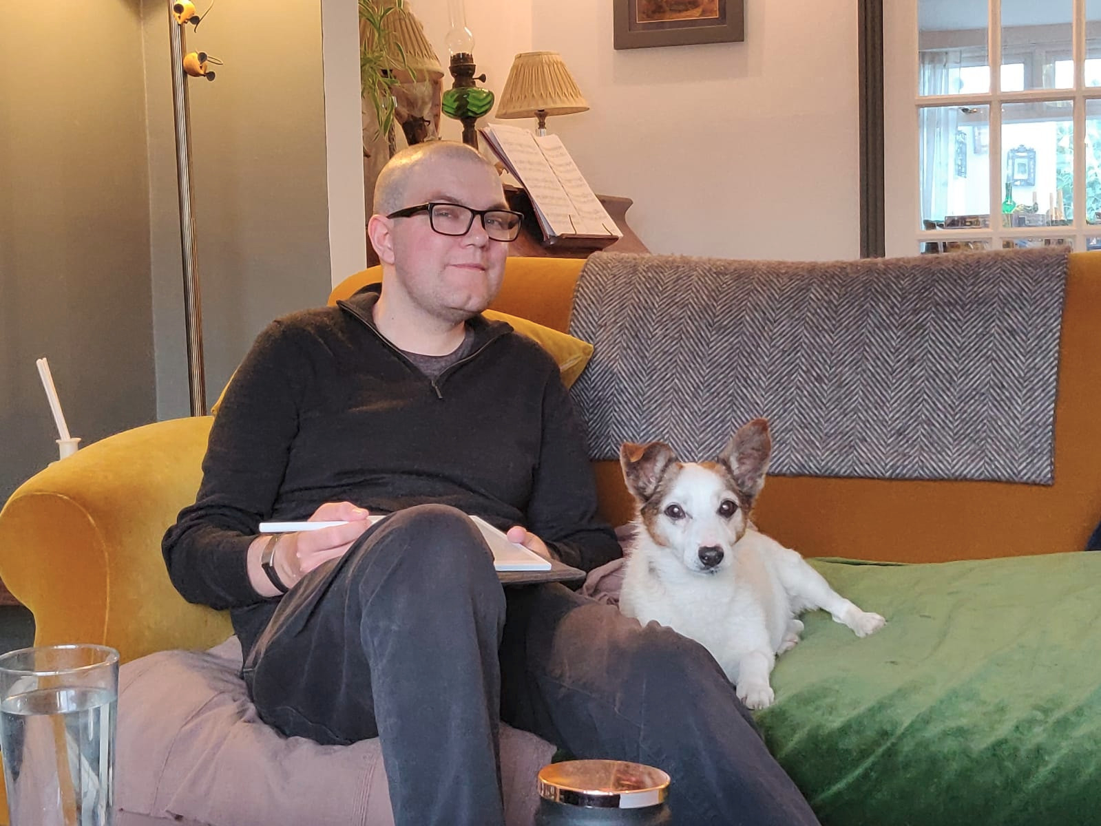 A picture of me studying (using a tablet device with a stylus) sitting next to my Jack Russell terrier, Toby