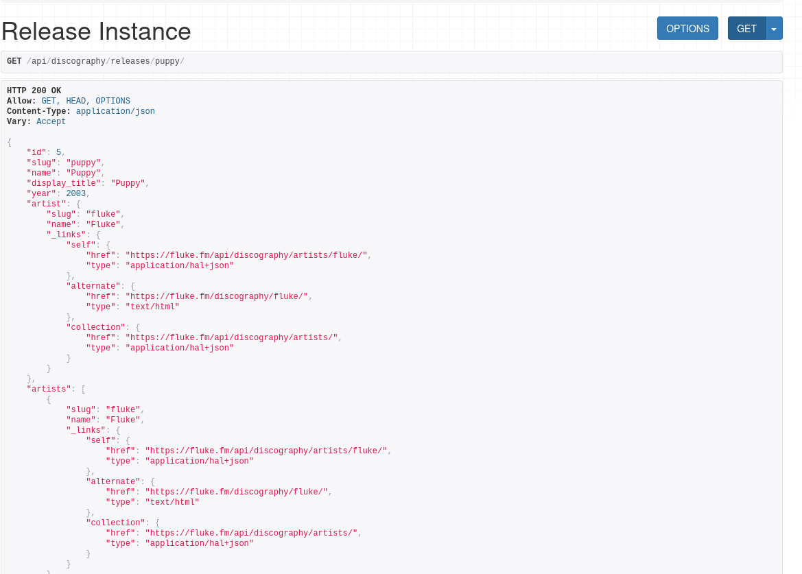 Screenshot of the Django REST Framework browsable API showing a successful GET /api/discography/releases/puppy/ request. The page heading reads “Release Instance,” with OPTIONS and GET buttons at top right. Below an HTTP 200 OK response header, formatted JSON describes the 2003 release “Puppy” by Fluke: ID 5, slug puppy, name and display title “Puppy,” and year 2003. Nested artist and artists objects include Fluke’s slug and name, plus HATEOAS-style links to the artist’s API endpoint, public HTML page, and the artists collection.