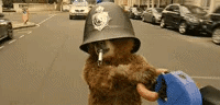 A scene from the Paddington film where he uses an umbrella to fly over a London bus